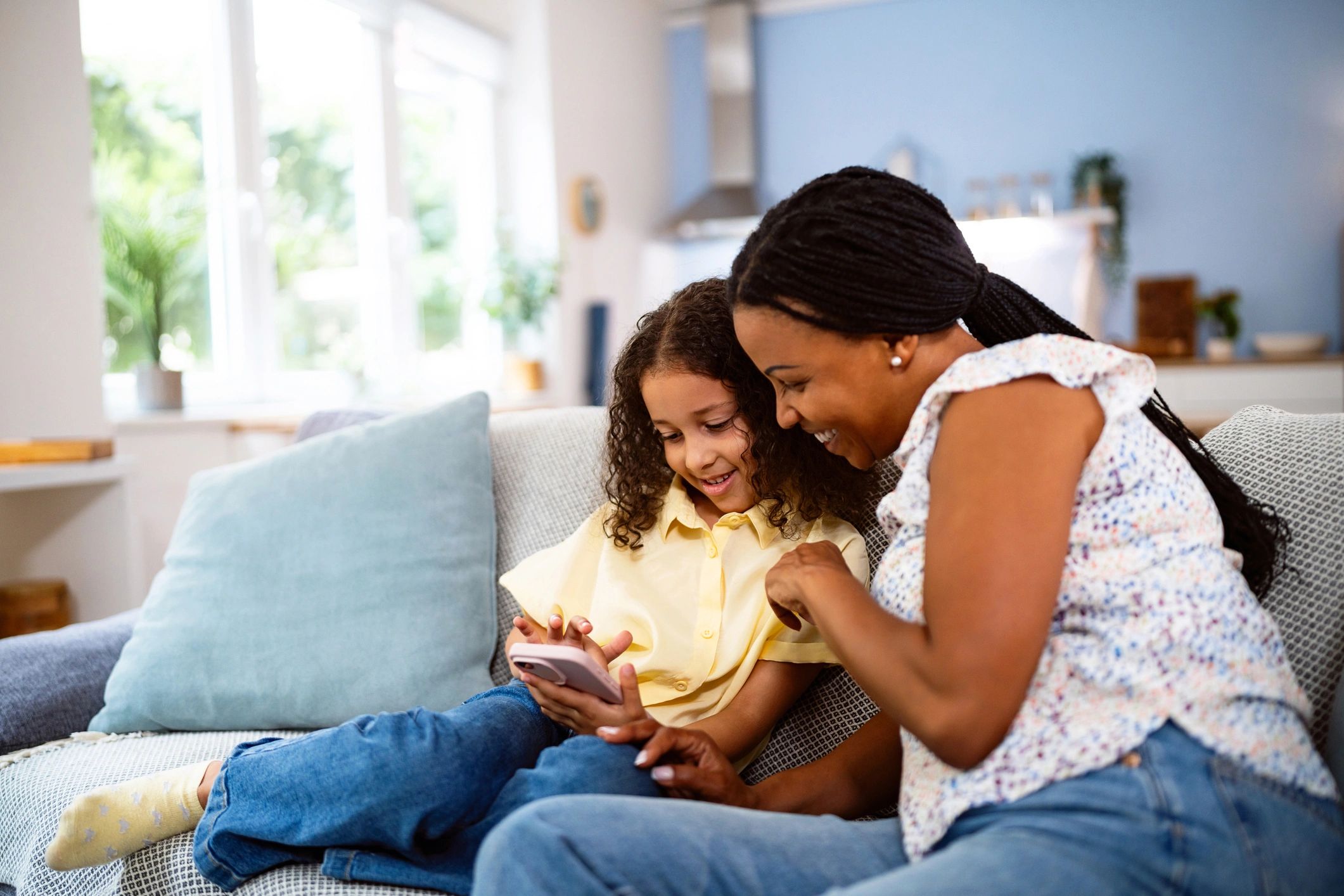 Parent reviewing information on a phone while sitting with a child