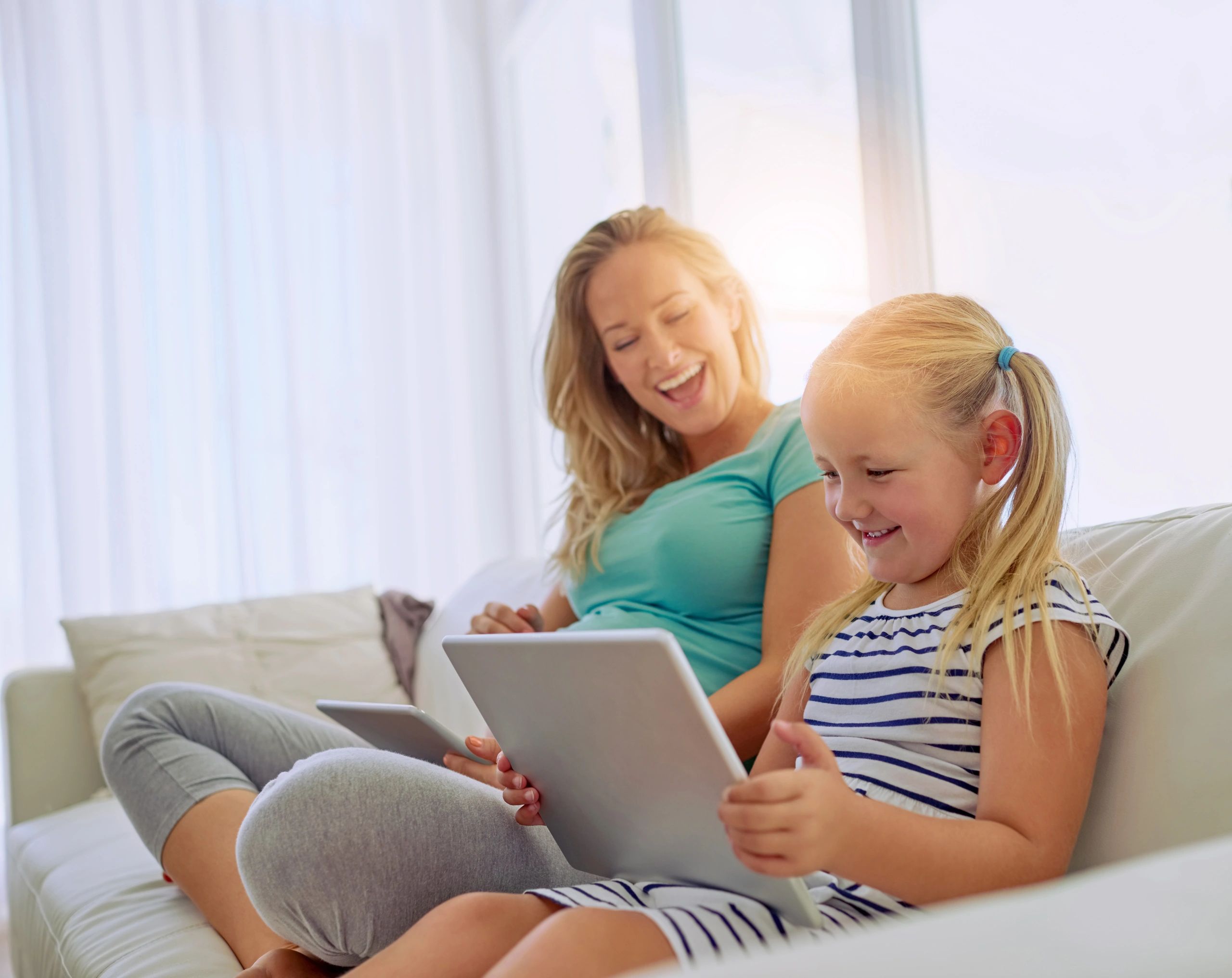 Parent and child using tablets at home